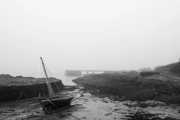 Jacht am Strand, wenn die Flut nachlässt und ein eisiger Nebel aufzieht. bla — Stockfoto