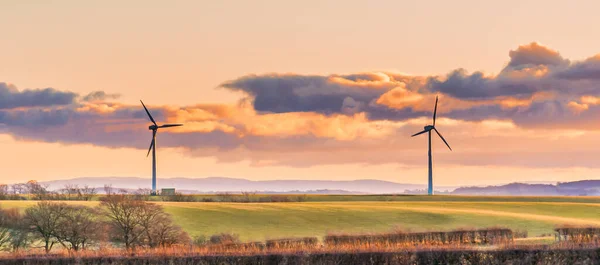 秋天的一个寒冷的苏格兰日 两个风力涡轮机 绿茵的田野 多云的天空 恰逢夕阳西下 天空充满了戏剧性的云彩 — 图库照片