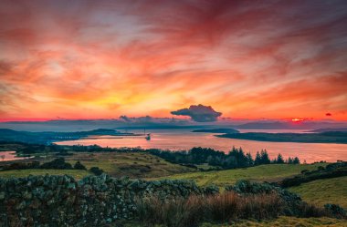 Gün batımında Largs 'ın arkasındaki tepelerden gelen Clyde Estuary..