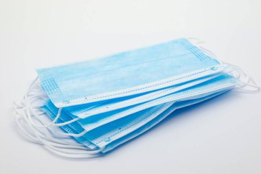 Tıbbi yüz maskeleri, Covid-19 Corona virüsünün yayılmasını engellemek amacıyla birçok ülkede kamu kullanımı için önerilen temel kişisel koruma ekipmanlarını maskelemektedir. Beyaz arkaplanda.