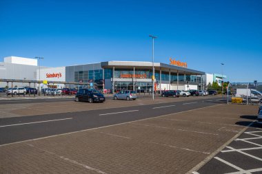 Irvine, Scotland, UK - May 11, 2020: Sainsburys Supermarket  Riverview Retail Park, and the famous statue of the boy with his boat, During a quiet period and one of the new retail facilities in the West of Scotland and petrol prices being low durin clipart