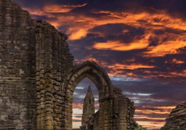 Eski Transept Kadim Harabeleri 'nin eski taş girişine ve Kilwin Abbey İskoçya' sında dramatik günbatımı gökyüzüne bakıyorum..