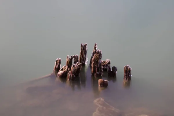 Daytime Long Exposure Stock Photo Remnants Icy Wooden Pylons Protruding — Stock Photo, Image