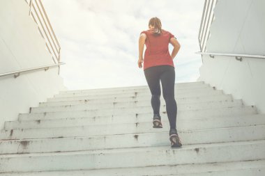 Merdivenlerde bir kadın koşuyor..