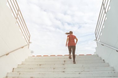 Merdivenlerde bir kadın koşuyor..