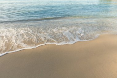 Sabahları beyaz kumların üzerinde dalgalanan deniz dalgaları..