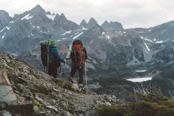 Twee mannen backpackers permanent op besneeuwde bergen — Stockfoto