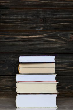  Koyu ahşap arka plan ile kitap yığını. Dikey orientatio