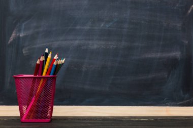 Okul kavramı. Arka plan olarak kara tahta ile kalemler