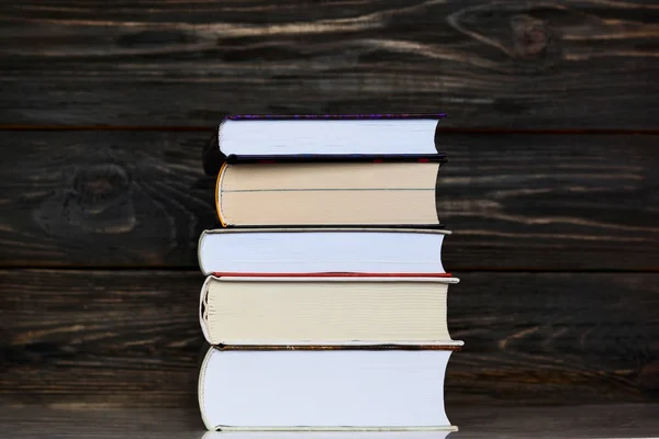 Bücherstapel mit dunklem, rustikalem Holzgrund. — Stockfoto