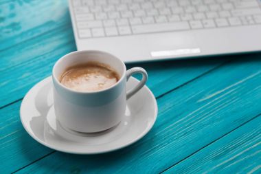 Kahve fincanı ve ahşap turkuaz arka üstünde laptop seçin