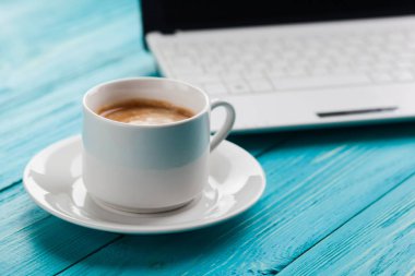 Kahve fincanı ve rustik ahşap turkuaz arka plan üstünde laptop