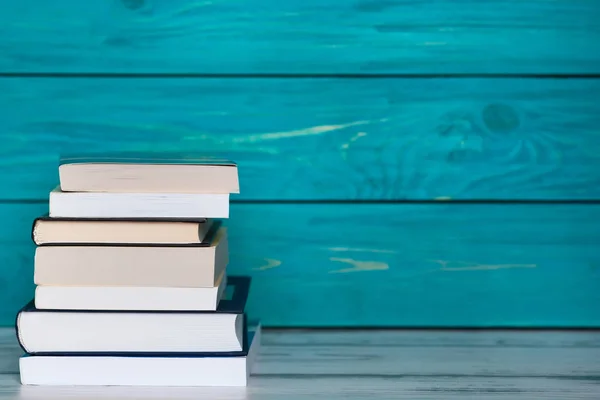 Bücherstapel auf türkisfarbenem Holzgrund. freier Platz für te — Stockfoto