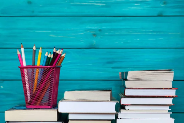 Libros y lápices sobre fondo azul madera. Contencioso educativo —  Fotos de Stock