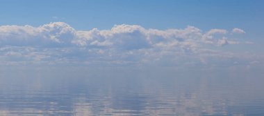 Derin mavi yüzey ile bulutlu gökyüzü birleştirme sakin bir deniz. İnci