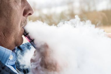 Orta yaşlı adam vaping elektronik sigara duman dolu