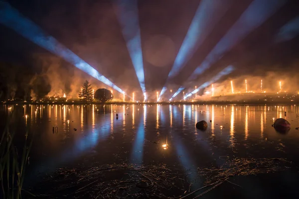 Spettacolo di ricerca con spettacolo di fuoco su un lago di notte — Foto Stock