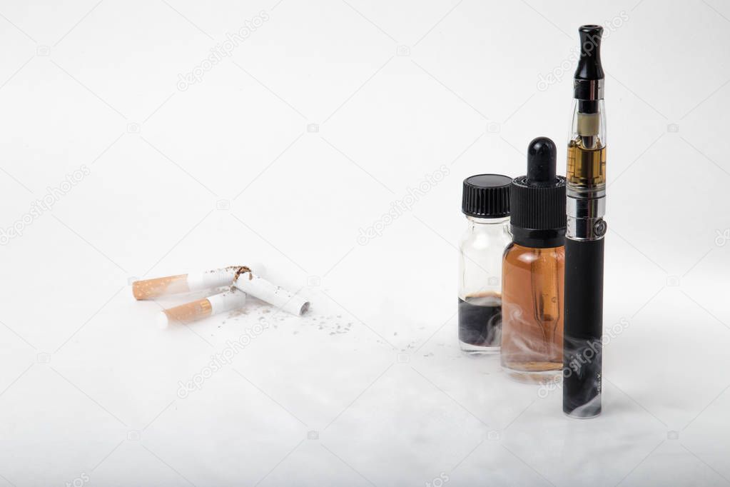 Broken tobacco cigarettes with modern electronic cigarette and e