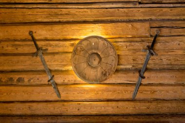 Viking kılıç ve küçük kalkan ahşap duvarda asılı