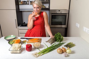 Kaplumbağa yerken mutfakta sevimli kız içki şarap cam 