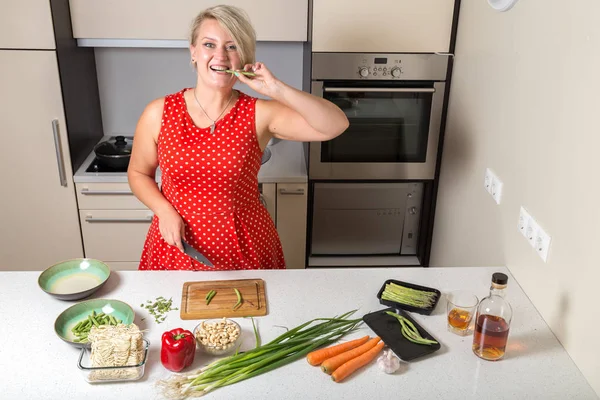 Kuşkonmaz ısırma ve diğer elinde bıçak tutan genç kadın