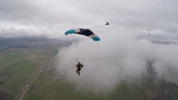 スカイダイバーは雲の間の空にパラシュートをパイロット — ストック動画