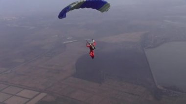 Skydiver pilotları paraşütünü gökyüzünde bulutların arasında uçuruyor..