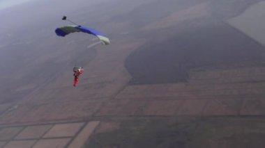 Skydiver pilotları paraşütünü gökyüzünde bulutların arasında uçuruyor..