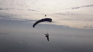 Skydiver pilotları paraşütünü gökyüzünde bulutların arasında uçuruyor..