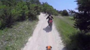 Motosikletliler dağlarda çakıllı bir yolda gezerler. Moto motorcu kayalık bir yolda motosiklet sürüyor.. 