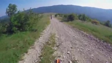 Motosikletliler dağlarda çakıllı bir yolda gezerler. Moto motorcu kayalık bir yolda motosiklet sürüyor.. 