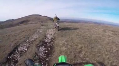 Motosikletliler dağlarda çakıllı bir yolda gezerler. Moto motorcu kayalık bir yolda motosiklet sürüyor.. 