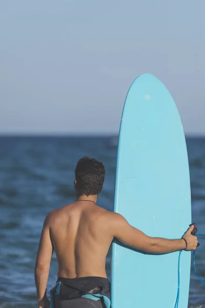 (Arkadan mavi onun surfboard holding sörfçü )