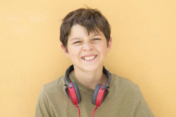 Ragazzo sorridente adolescente in posa all'aperto. Guardando la fotocamera con headpho — Foto Stock