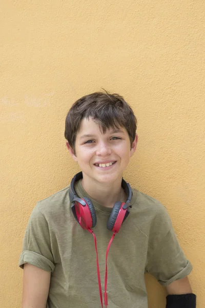 Ragazzo sorridente adolescente in posa all'aperto. Guardando la fotocamera con headpho — Foto Stock