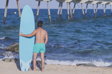 (Arkadan mavi onun surfboard holding sörfçü )