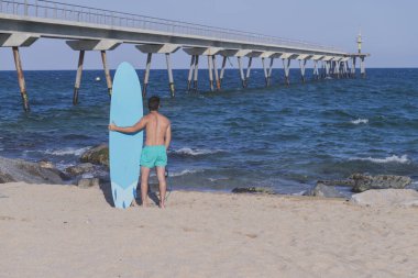 (Arkadan mavi onun surfboard holding sörfçü )