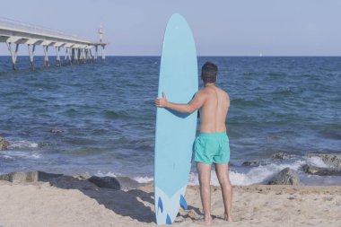 (Arkadan mavi onun surfboard holding sörfçü )