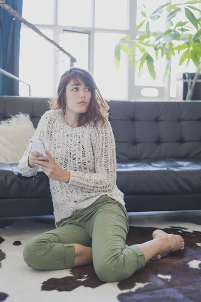 Mujer alegre hablando por teléfono móvil, sentada en la sala de estar — Foto de Stock