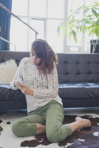 Gladlynt kvinna tala i mobiltelefon, sitter på vardagsrum — Stockfoto