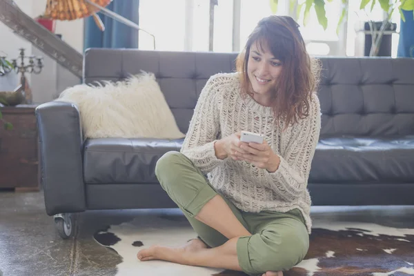 Mujer alegre hablando por teléfono móvil, sentada en la sala de estar — Foto de Stock