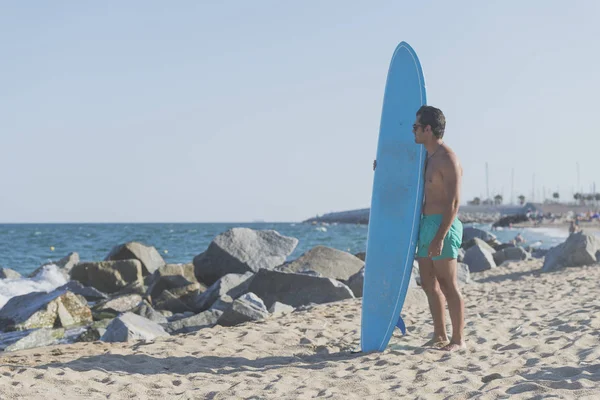 Mavi onun surfboard holding sörfçü