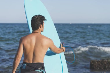 Sörfçü arkadan mavi onun surfboard taşıma