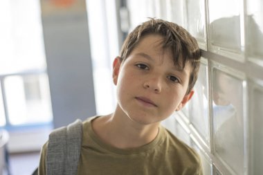 Okul üzerinde dinlenme ve bir cep telefonu ile oynarken öğrenci