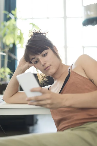 Retrato de la joven empresaria feliz usando el teléfono móvil en offi — Foto de Stock