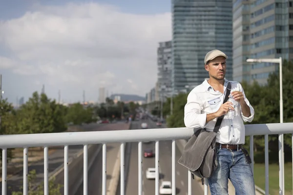 Portret van een jonge en mannelijke man een drinkwater buiten — Stockfoto