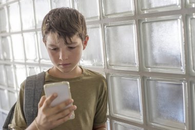 Okul üzerinde dinlenme ve bir cep telefonu ile oynarken öğrenci