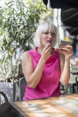 Güzel sarışın kadın bir gümüş ayna - sıklıkta kullanarak yapma
