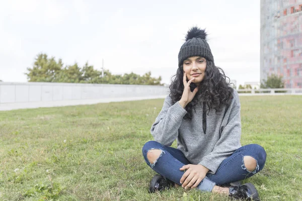 Retrato de una mujer con gorra de lana y suéter en el parque — Foto de Stock