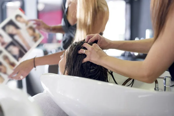 Young woman washing hair in salon